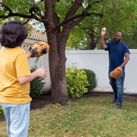 Dad and son play catch in their backyard are better protected by TruStage Life Insurance.