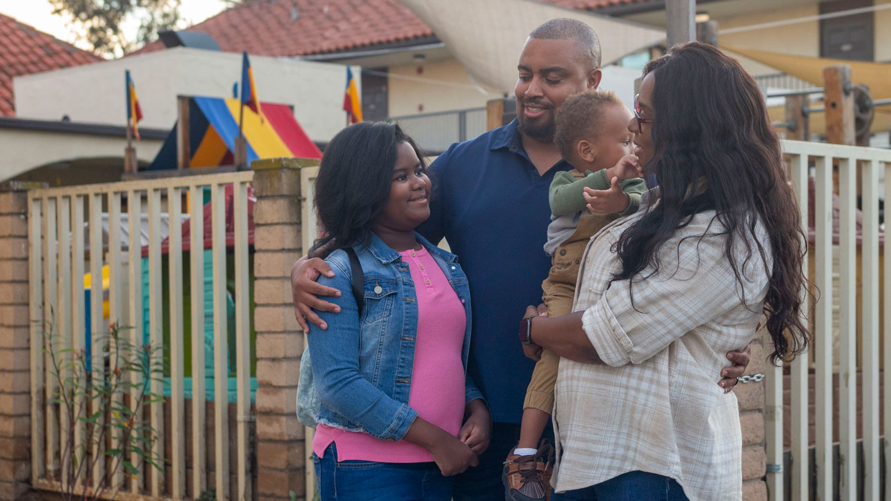 A family smiles happily together because of TruStage payment guard