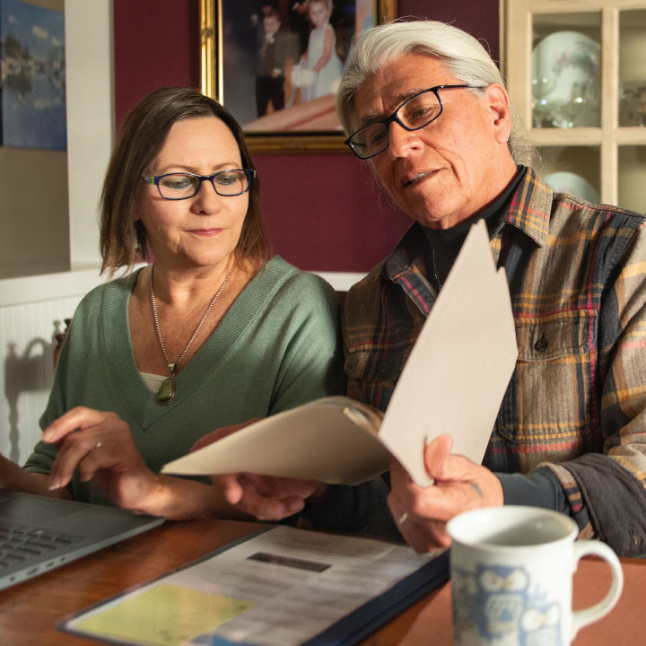 A husband and wife looking at their life insurance policy