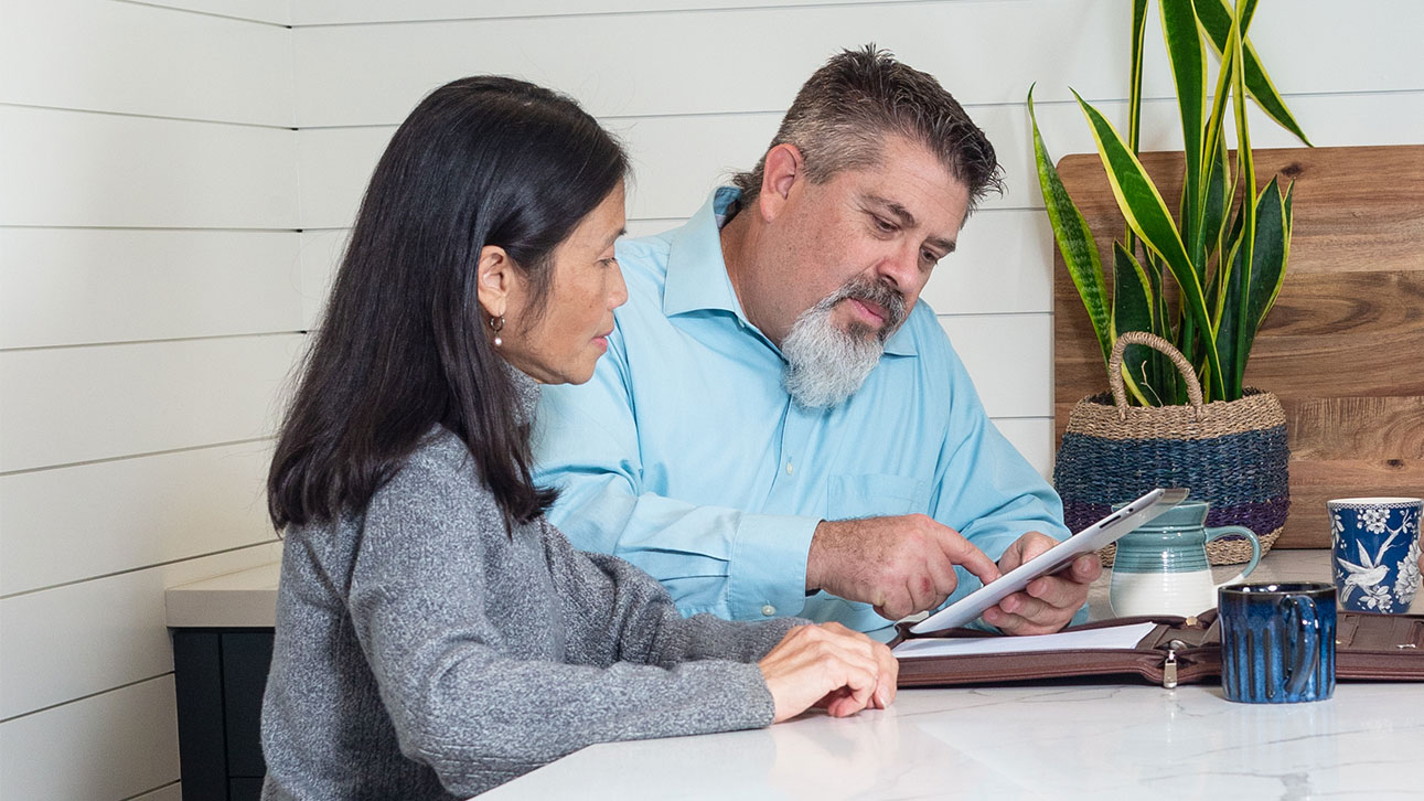 Two people gathered around a table reviewing TruStage's lending resource center