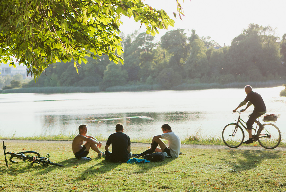 Man riding bike while small group of people talk about TruStage financial services