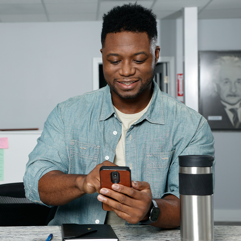 A man looks at his phone smiling