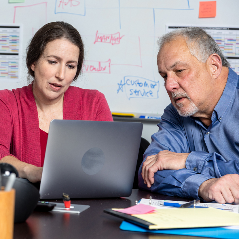 Man and woman sitting together in front of laptop