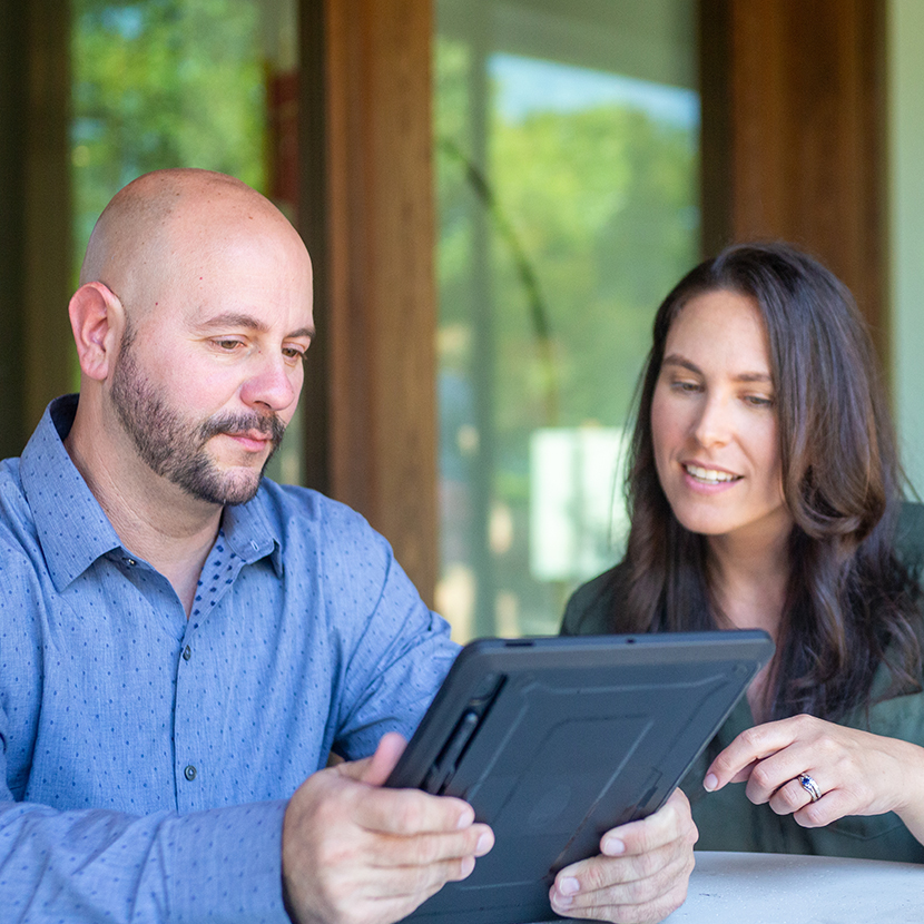 A woman and a man look at a tablet together