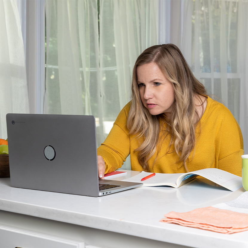 Woman working in front of her laptop sitting at a table