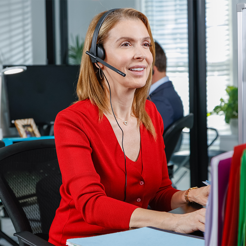 Woman working at her desk with her headset on