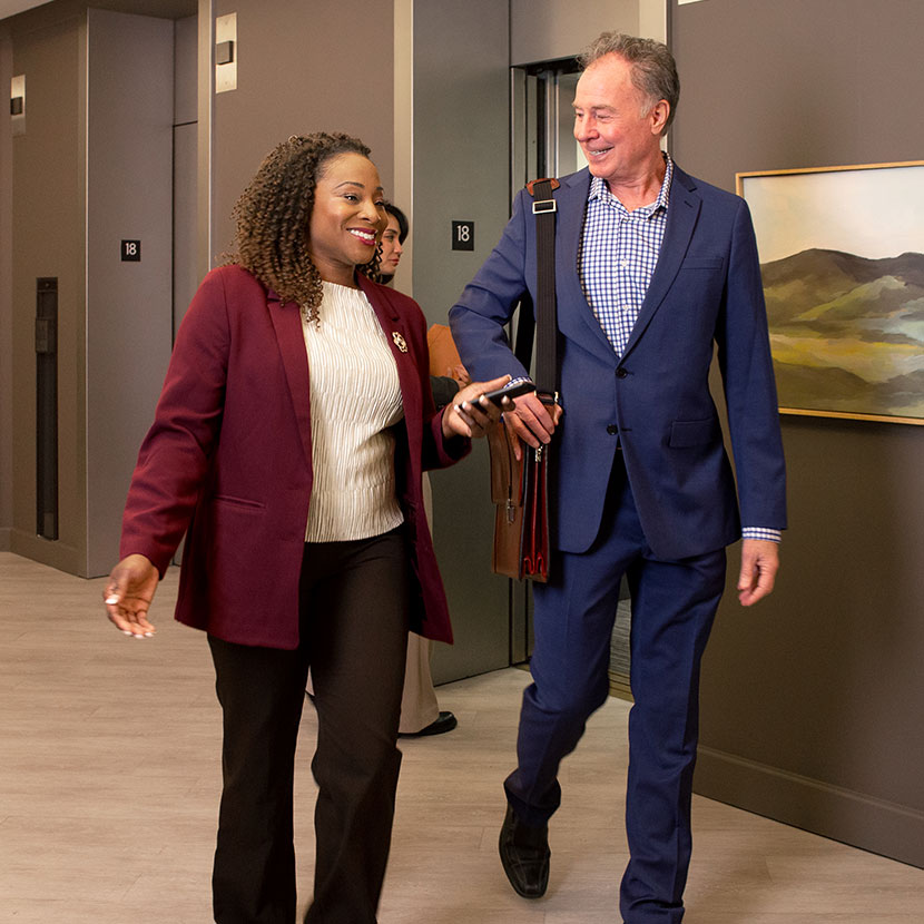 Two people walk and talk about TruStage business protection resources together