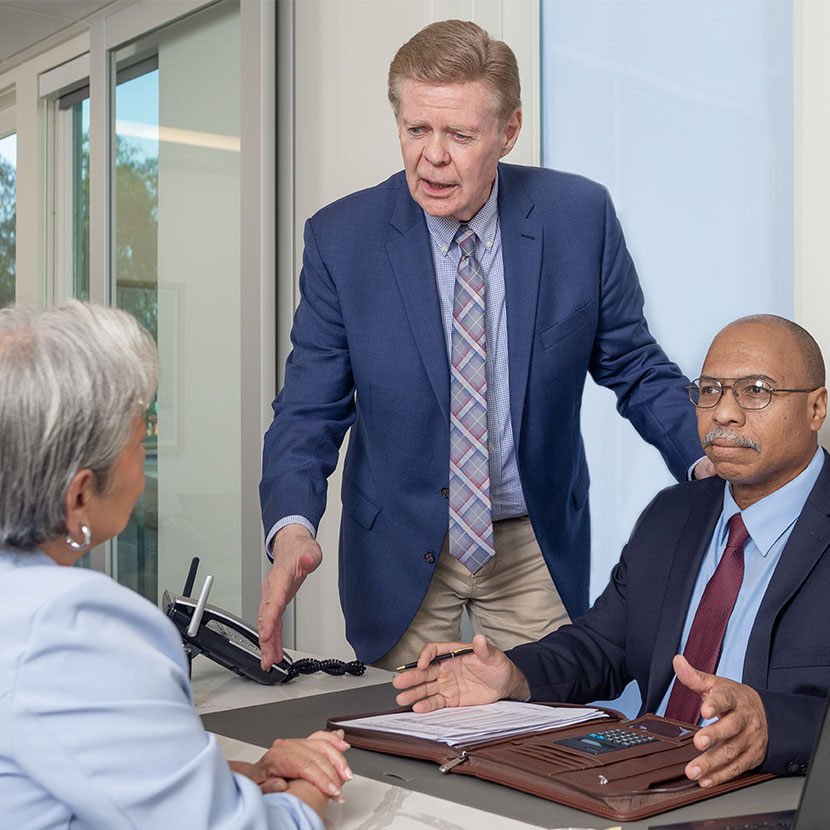 A few people discuss TruStage business protection resources around a table