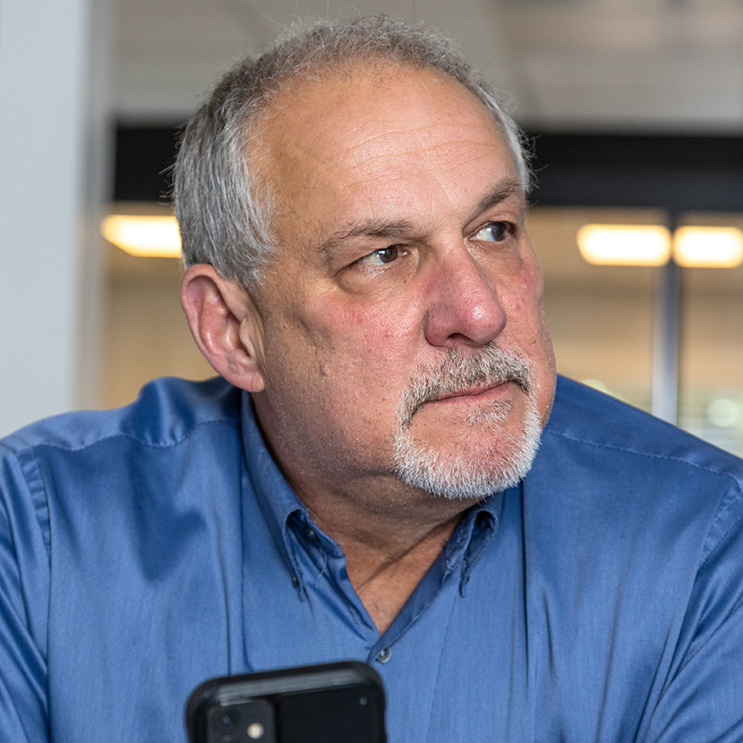 A man holding his phone looking away