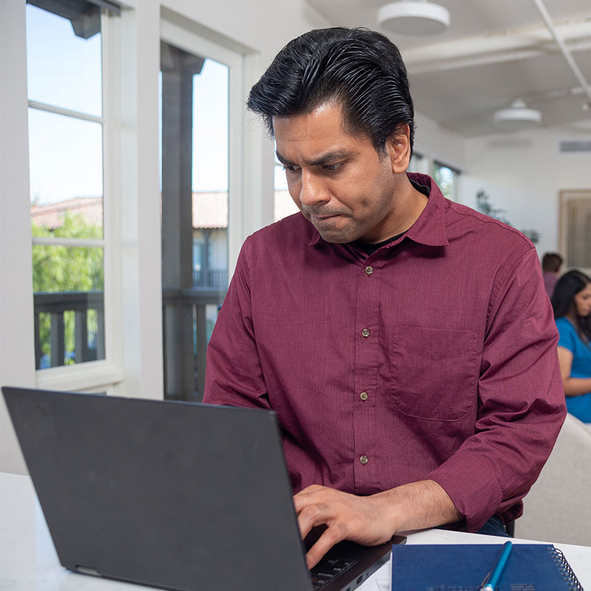 A man smiles while learning about TruStage on his laptop