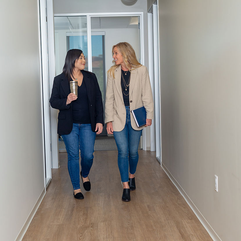 Two women walk and talk about TruStage business protection resources