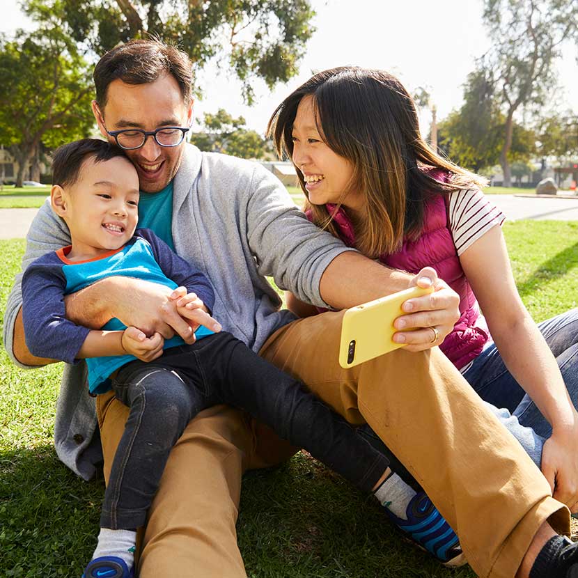 Two parents and their son take a photo outside after seamlessly applying for TruStage life insurance.
