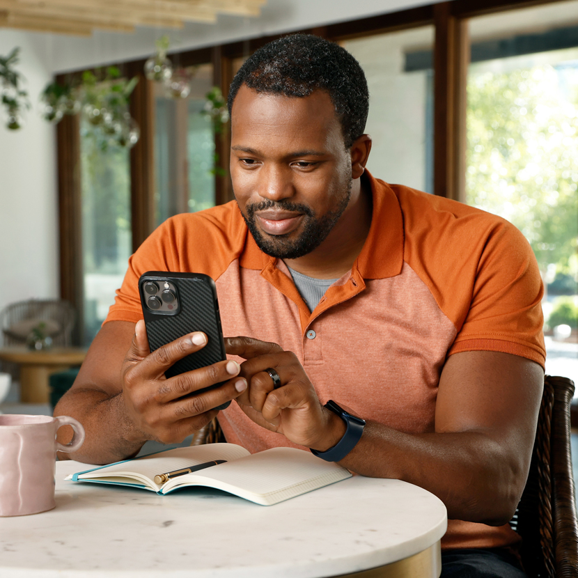 Man using phone at a coffee table