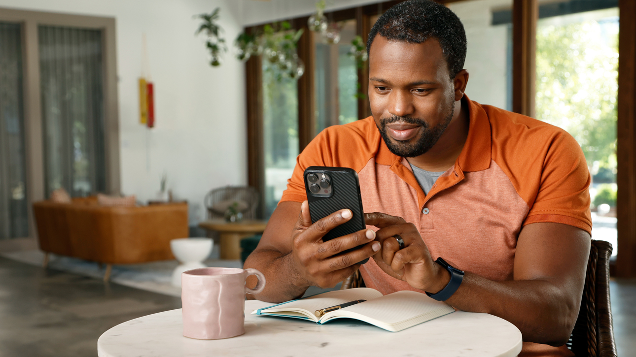 Man using phone at a coffee table