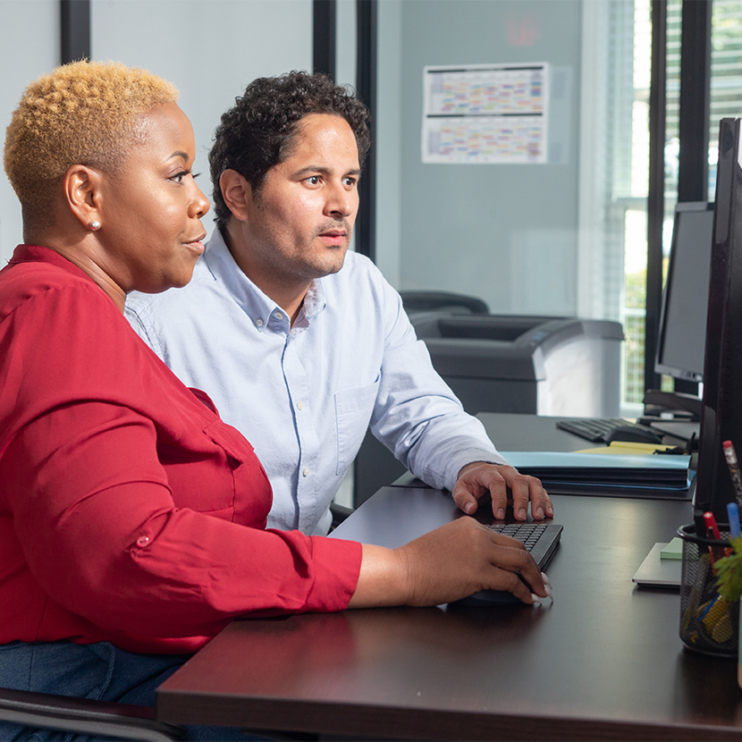 A woman and a man sitting together looking at a computer