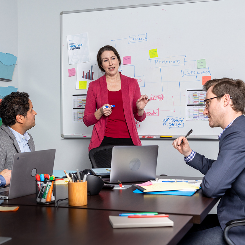 Woman conducting meeting with two coworkers