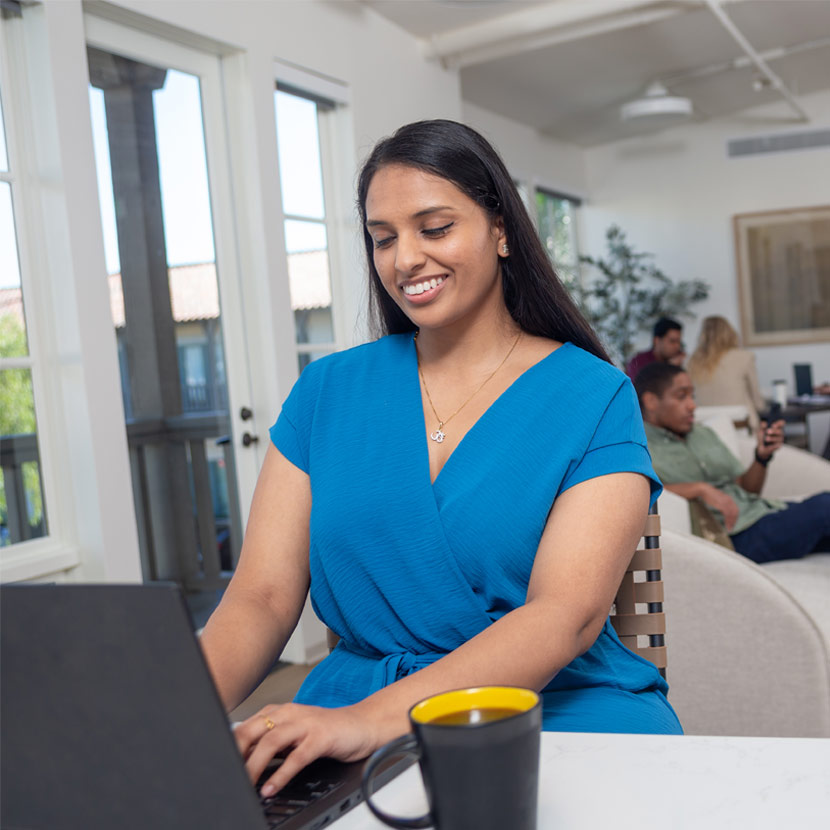 A woman uses a laptop to read that TruStage Payment Guard Insurance has been selected as a Banking Tech Awards USA finalist.