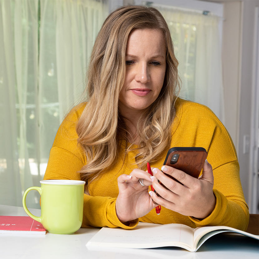 Woman looking at her phone, using the new TruStage Digital Deposit solution