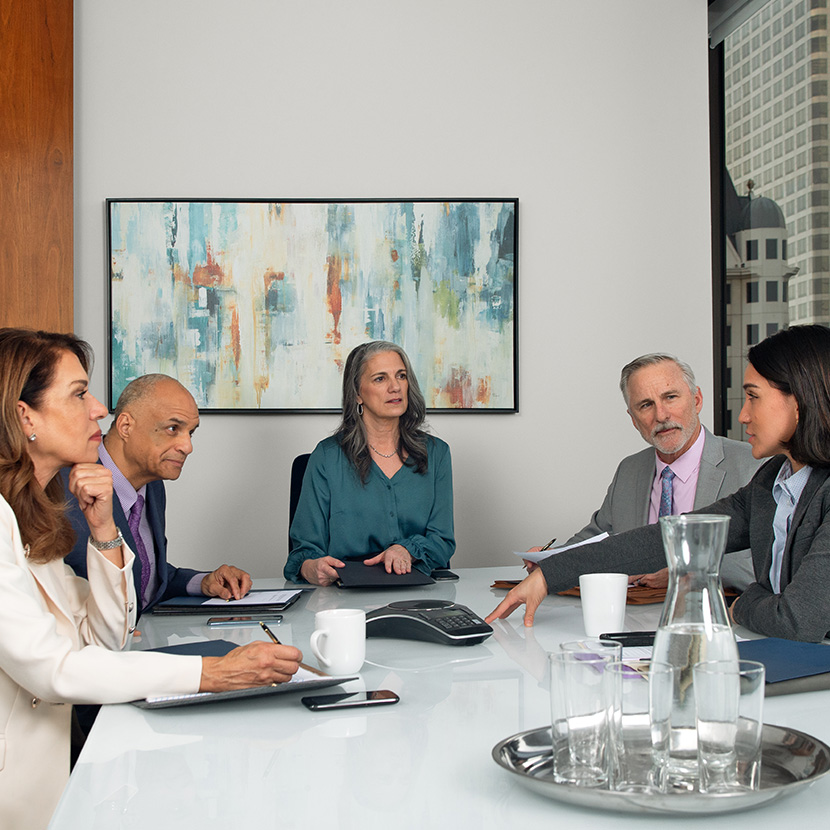 Five business professionals sit in an office discussing how the Digital Storefront supports credit unions and community banks.