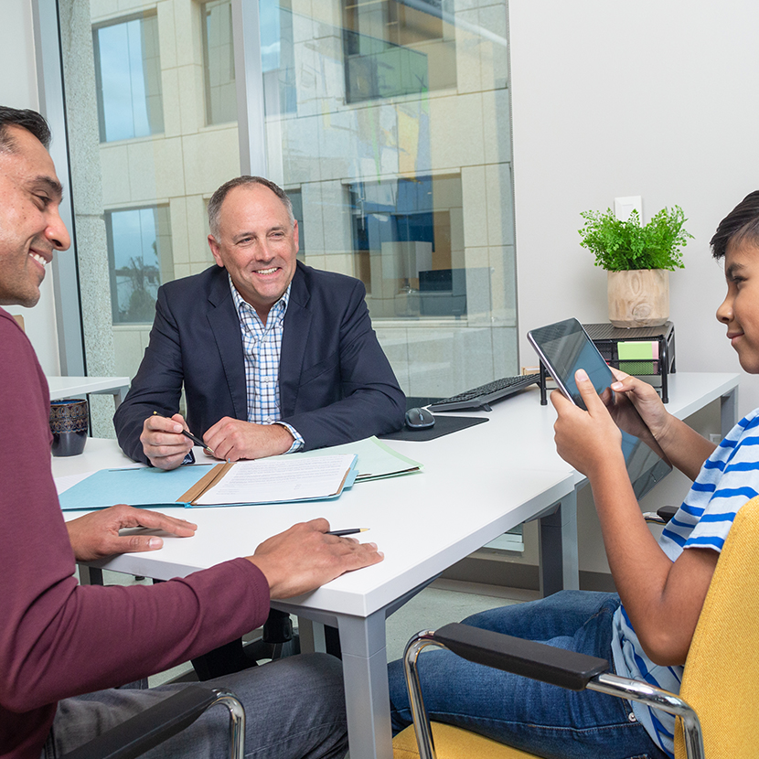 Father and son speaking with advisor