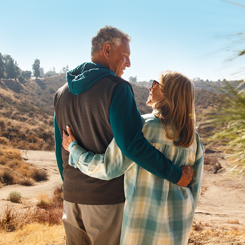 A man and woman embrace one another, feeling relieved they have flexibility for retirement planning with TruStage.