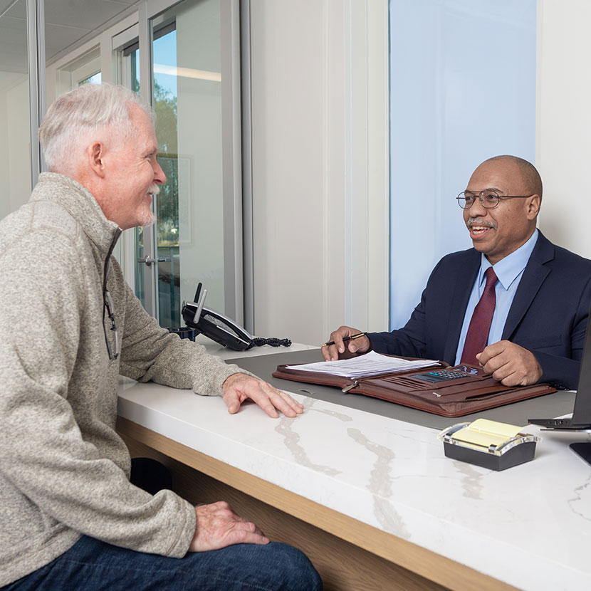 A client and his financial professional discuss how to protect assets and reach long term goals during volatile markets