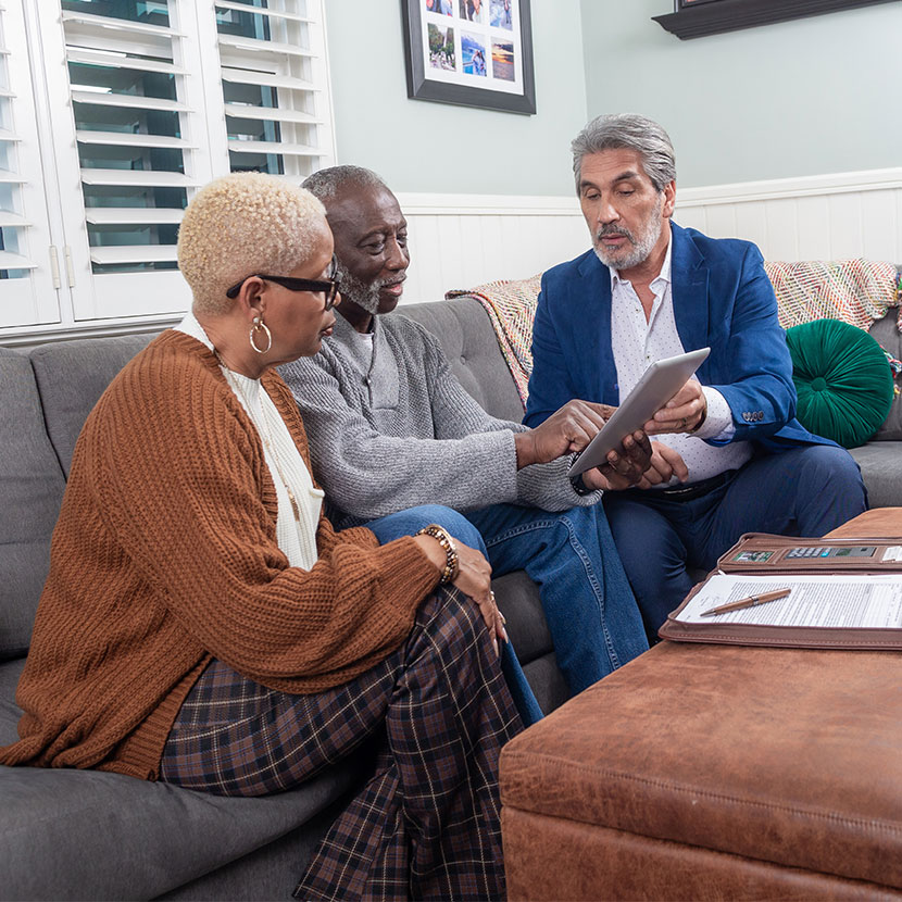 Three people sitting on a couch talking about guaranteed lifetime withdrawal benefits