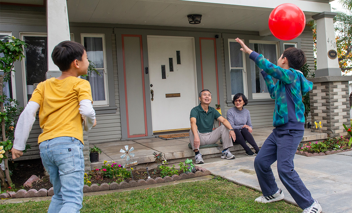 Parents on a front step watching their children play are secure in their retiremnt thanks to Single Premium Immediate Annuity