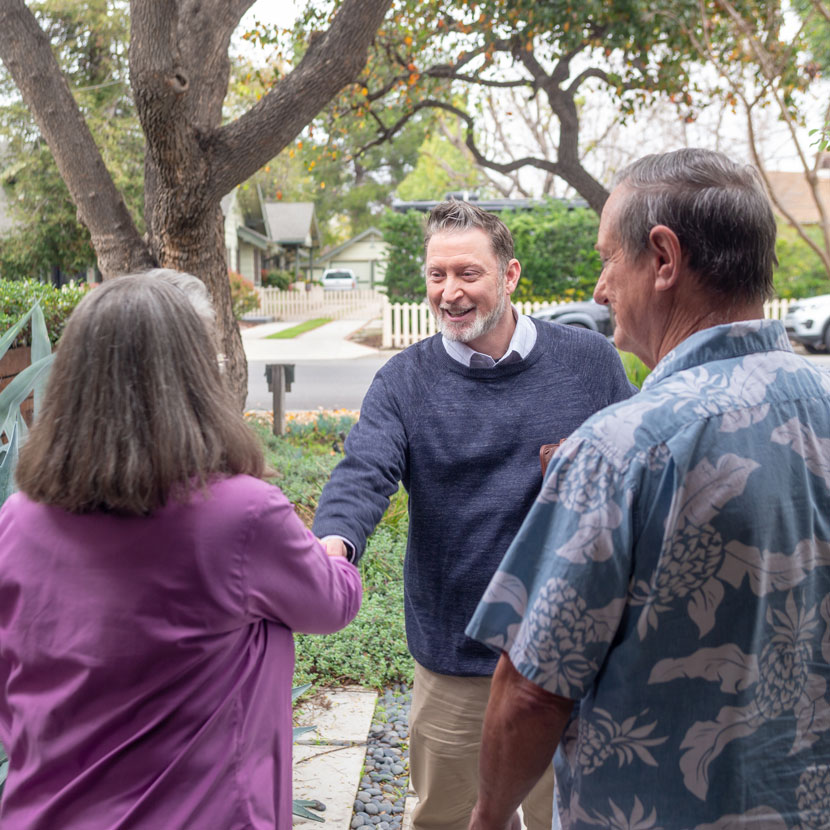 Three people shake hands and discuss TruStage business auto insurance
