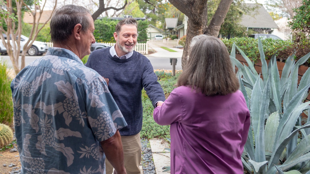 Three people shake hands and discuss TruStage business auto insurance