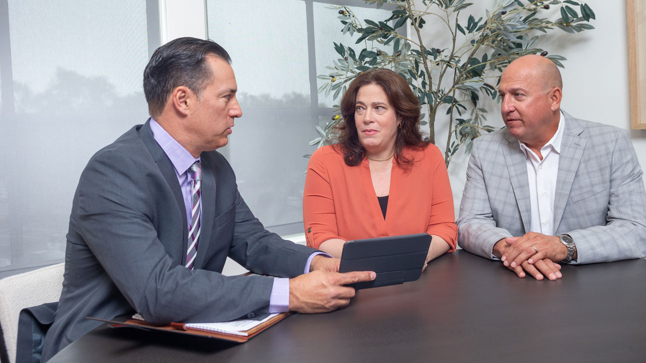 Three people sit around discussing TruStage's business protection solutions