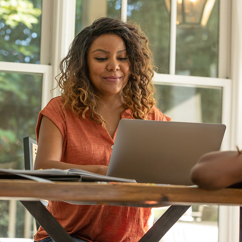 A woman using her laptop is offered a personalized deposit opening experience from her financial institution.