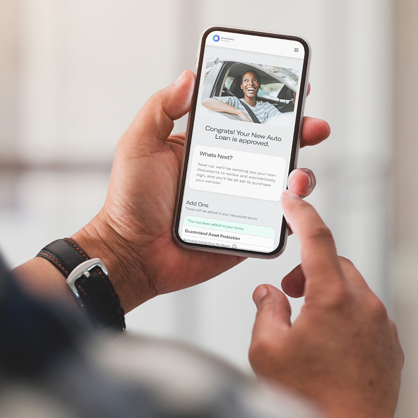 A consumer uses their phone to complete an auto loan application made available through use of the Digital Storefront.