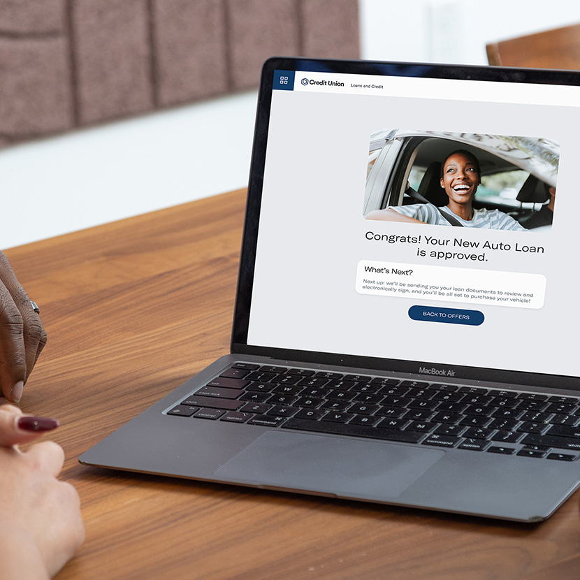 A woman uses her laptop to complete an auto loan application made available through the Digital Storefront.