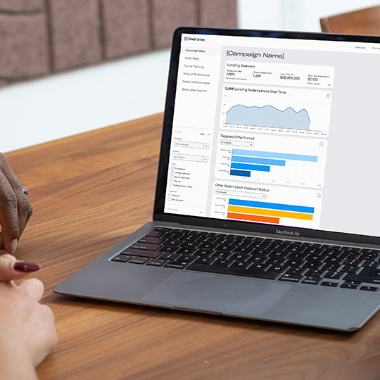 A financial professional uses a laptop to review campaign performance in the Digital Storefront admin portal.