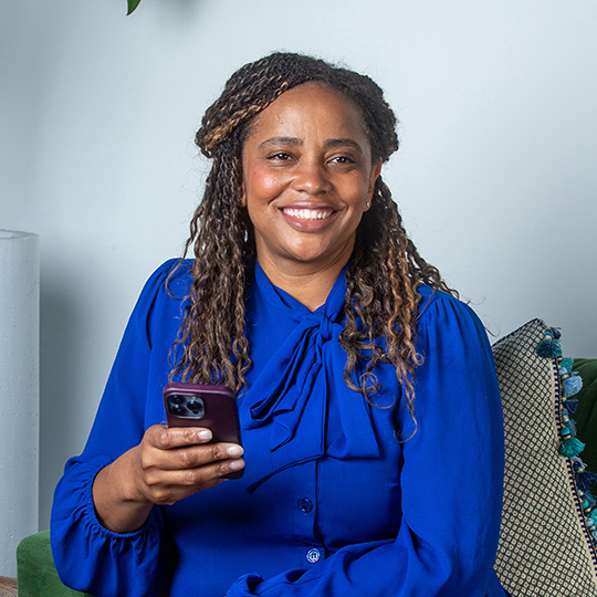 A woman uses her phone to review product offers she has matched with using rules her financial organization has set.