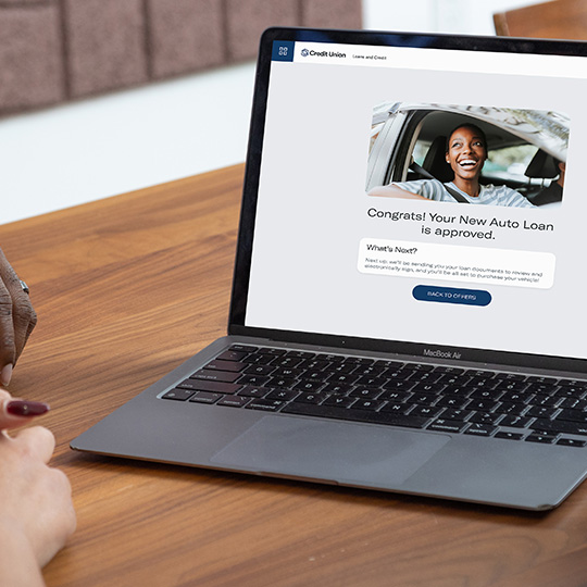 A woman uses her laptop to complete an auto loan application made available through the Digital Storefront.