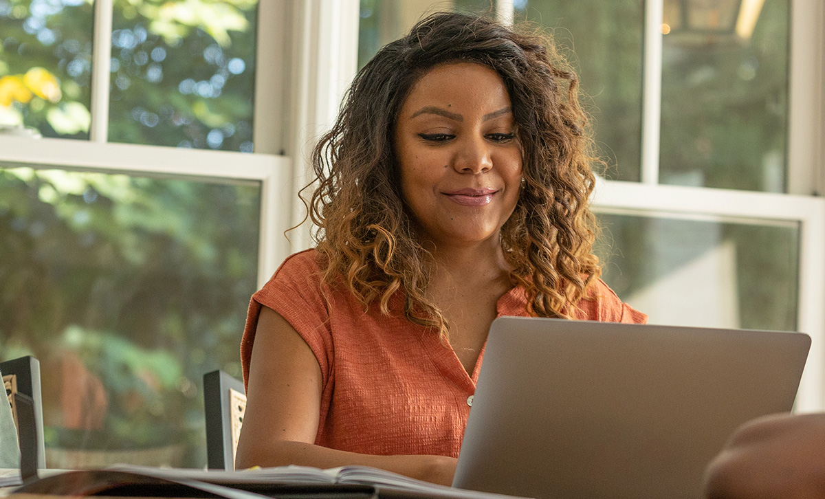A woman using her laptop is offered a personalized deposit opening experience from her financial institution.