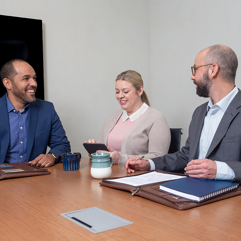 Three people sit around discussing TruStage fiduciary investment consulting