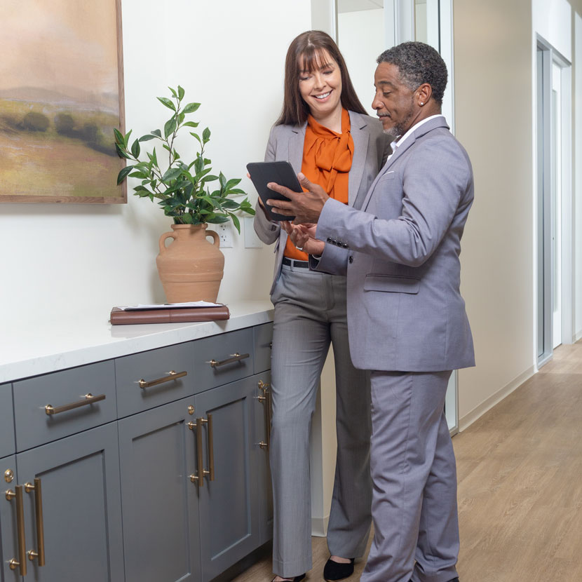 Two people stand and discuss TruStage lender support services