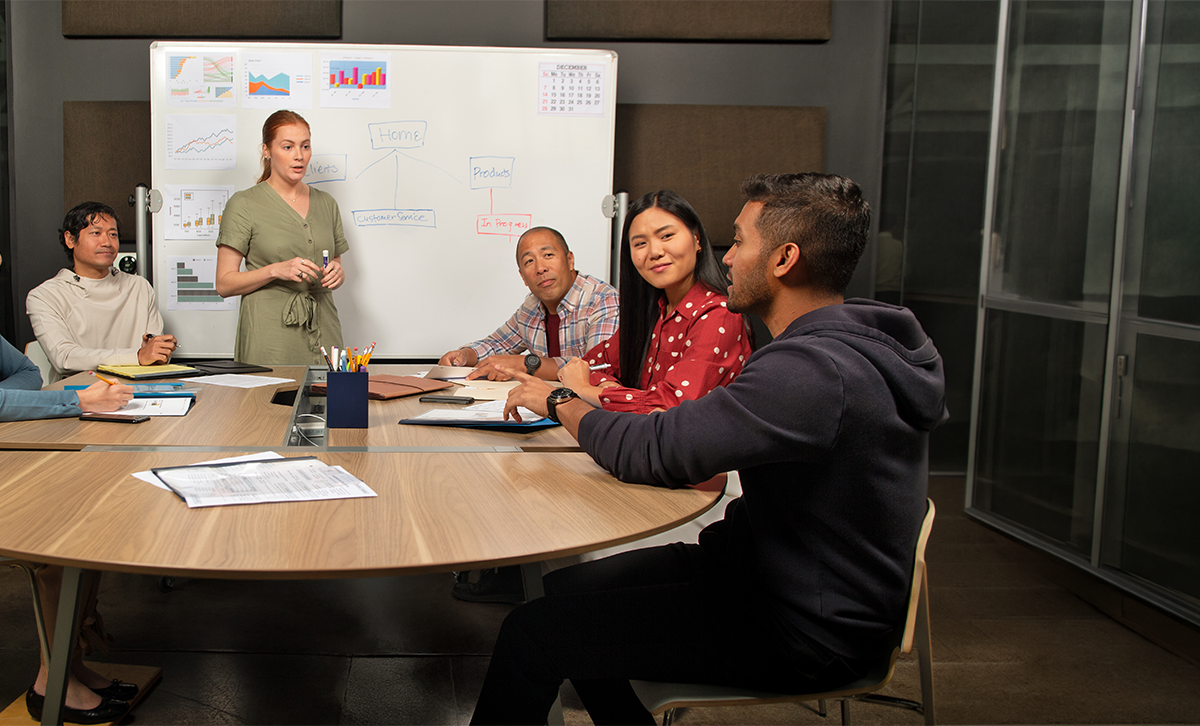 A team sitting around a table collaborating about the Lender Development Program.