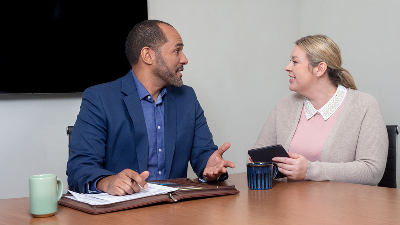 Two people sitting at a table discussing TruStage lending