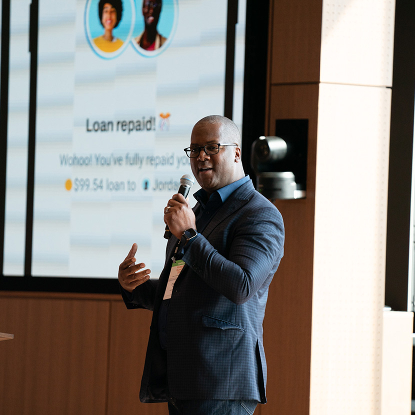 Man holding microphone speaking at a conference