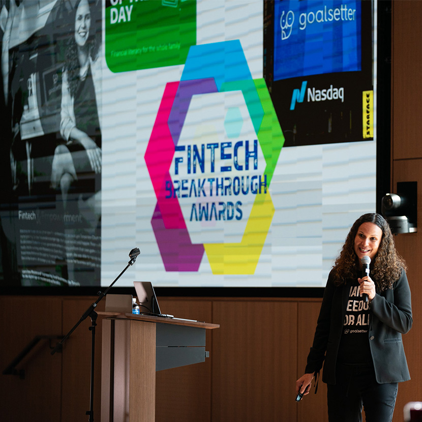 Woman holding a microphone speaking at a conference