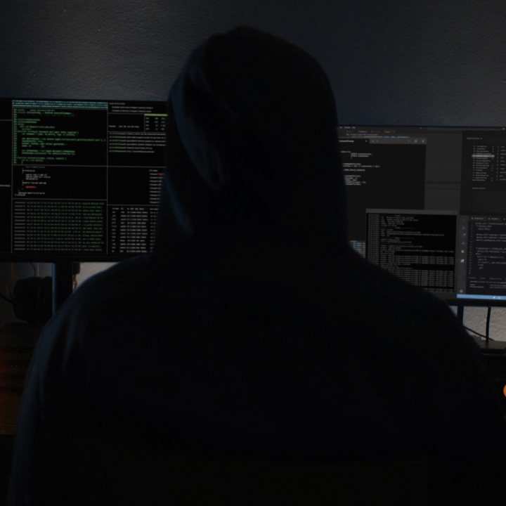 A scammer sits behind a computer attempting to obtain personal information from unsuspecting individuals.