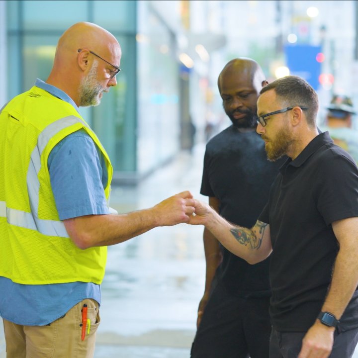 Three men discuss life insurance while taking a smoke break.