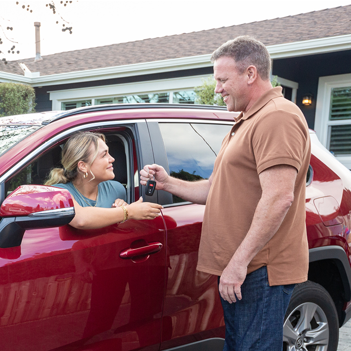 A father hands his daughter car keys after ensuring she has liability insurance.