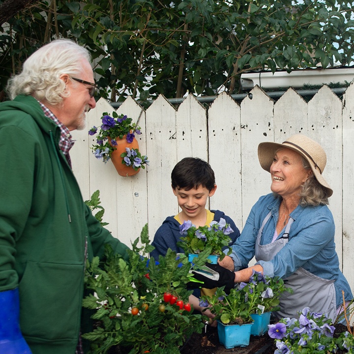 A husband and wife discuss the importance of whole life insurance while gardening with their grandson.