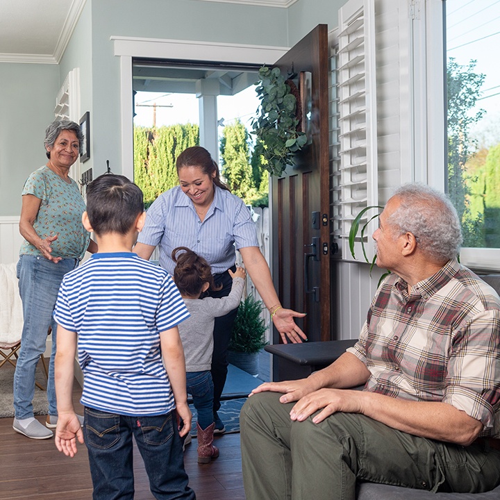Children greet their mother at the front door.